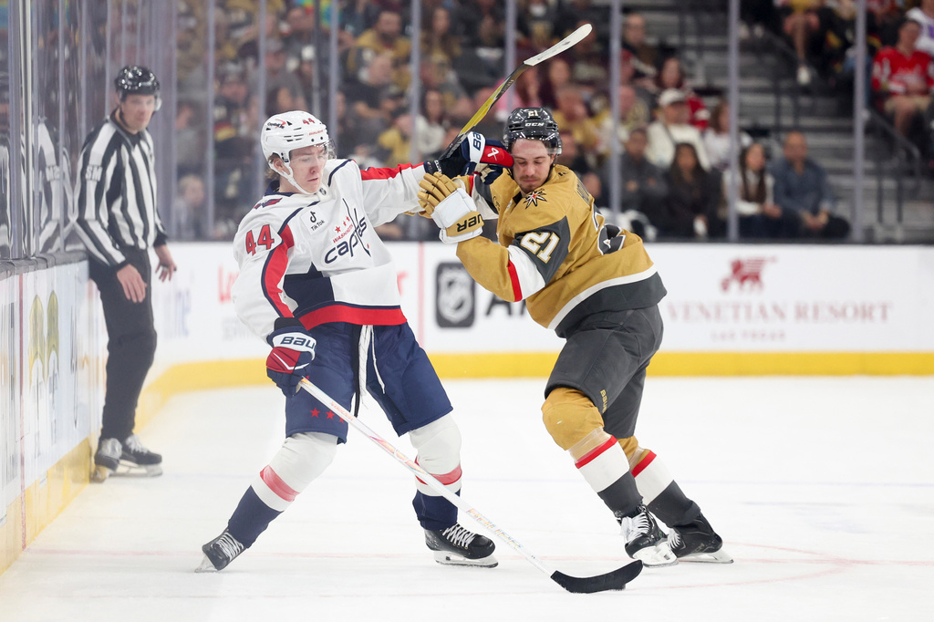 Washington Capitals defenseman Cole Hutson (44) pushes Vegas Golden Knights center Brett Howden (21) while contesting for the puck during the first period of an NHL hockey game Saturday, March 28, 2026, in Las Vegas. (AP Photo/Ian Maule)