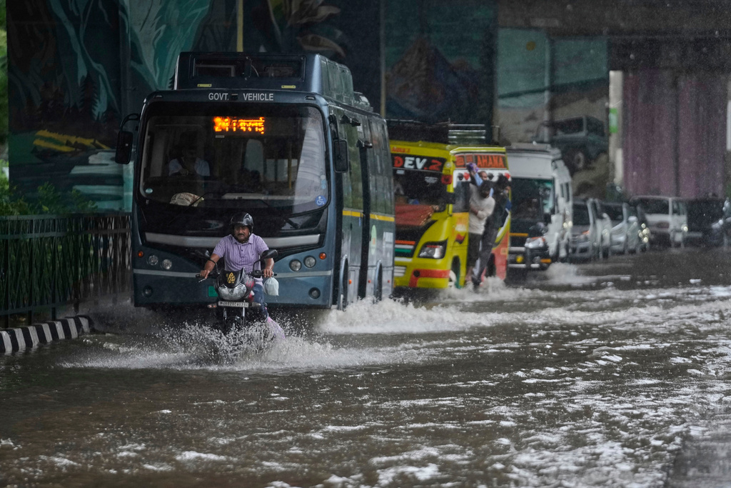 Commuters move through a flooded road after heavy rain in Jammu, India, Tuesday, Aug. 26, 2025.(AP Photo/Channi Anand)