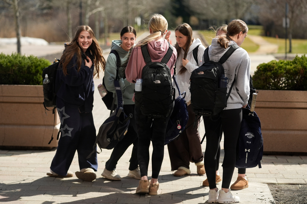 Students enjoy a light moment outside Hanover High School, Wednesday, March 25, 2026, in Hanover, Mass. (AP Photo/Robert F. Bukaty)