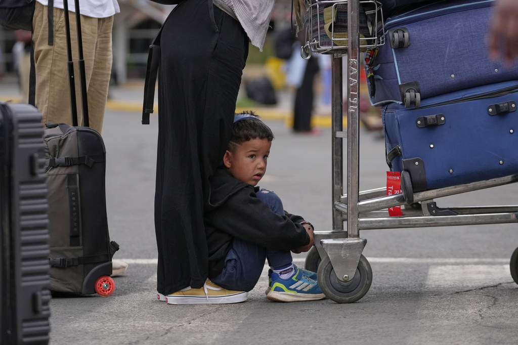 A child sits on the floor as passengers wait for delayed flights during a workers strike at Jomo Kenyatta International Airport in Nairobi, Kenya, Monday, Aug. 31, 2026. (AP Photo/Brian Inganga)