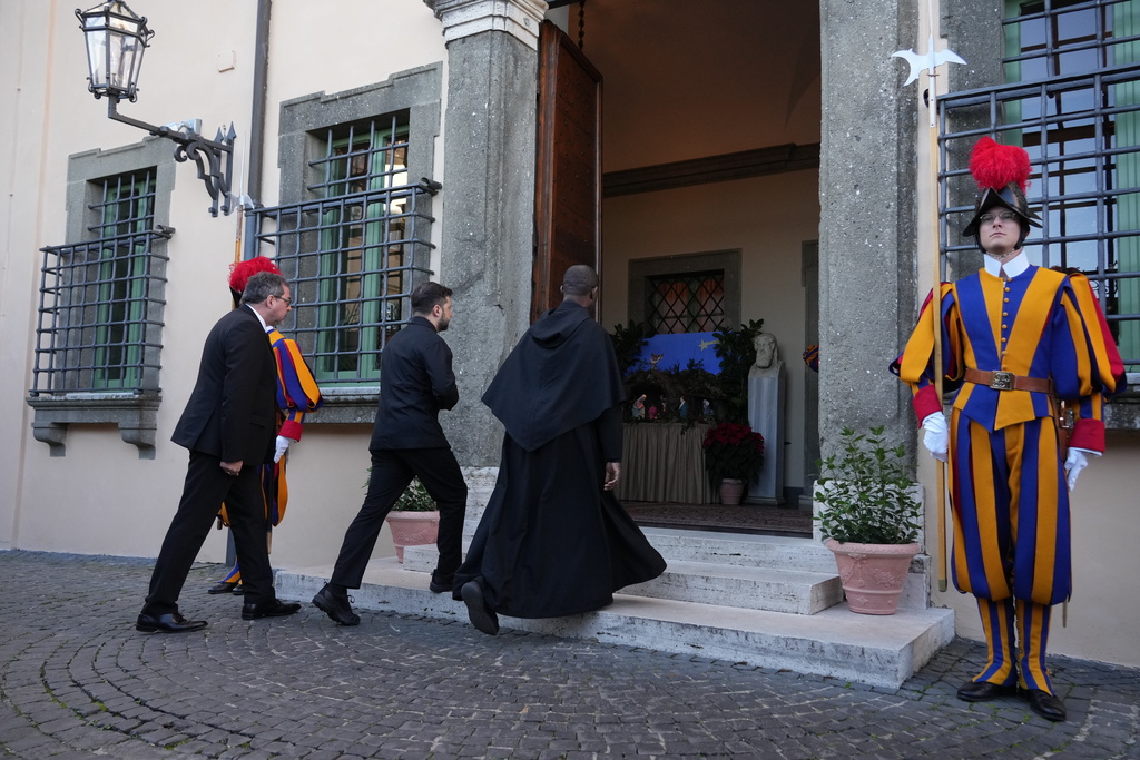 Ukraine President Volodymyr Zelenskyy, center, walks past Swiss guards as he arrives to meet with Pope Leo XIV in Castel Gandolfo, Italy, Tuesday, Dec. 9, 2025. (AP Photo/Andrew Medichini)