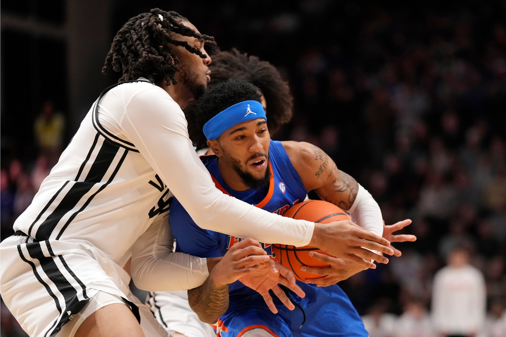 Florida's Boogie Fland, right, drives against Vanderbilt's Devin McGlockton, left, in the first half of an NCAA college basketball game Saturday, Jan. 17, 2026, in Nashville, Tenn. (AP Photo/Mark Humphrey)