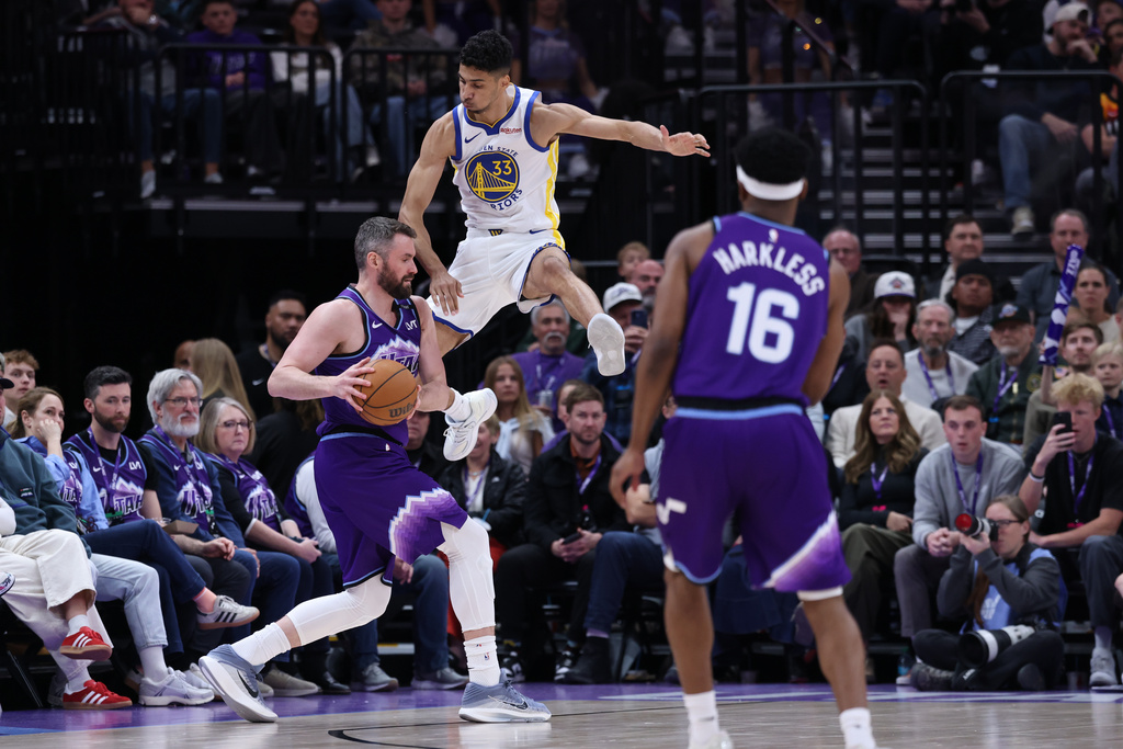 Utah Jazz forward Kevin Love, left, is fouled by Golden State Warriors forward Malevy Leons (33) while going up for a 3-point shot during the second half of an NBA basketball game, Monday, March 9, 2026, in Salt Lake City. (AP Photo/Rob Gray)