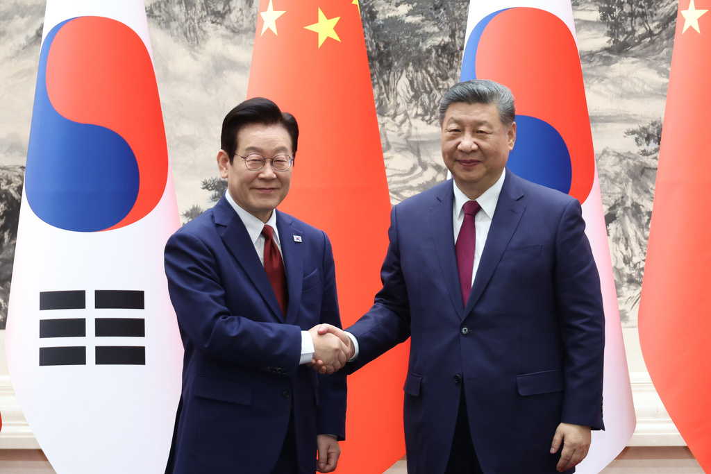 Chinese President Xi Jinping, right, shakes hands with South Korean President Lee Jae Myung, left, during a ceremony of the Memorandum of Understanding, (MOU) between South Korea and China in Beijing, China, Monday, Jan. 5, 2026. (Han Sang-kyun/Yonhap via AP)