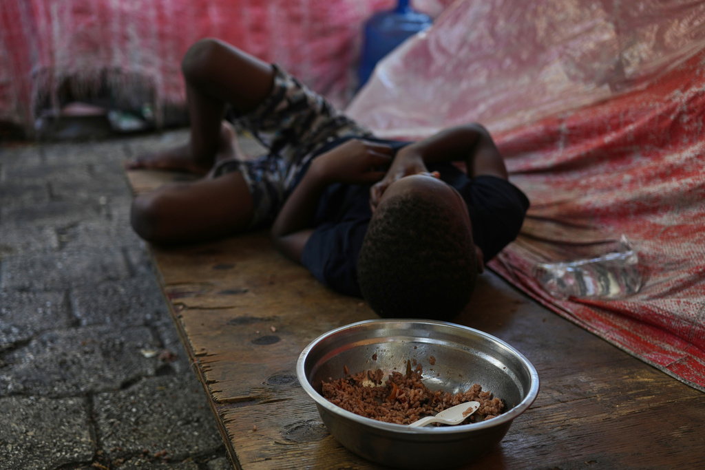 A child plays at a shelter for families displaced by gang violence as he eats a meal in Port-au-Prince, Haiti, Monday, March 16, 2026. (AP Photo/Odelyn Joseph)