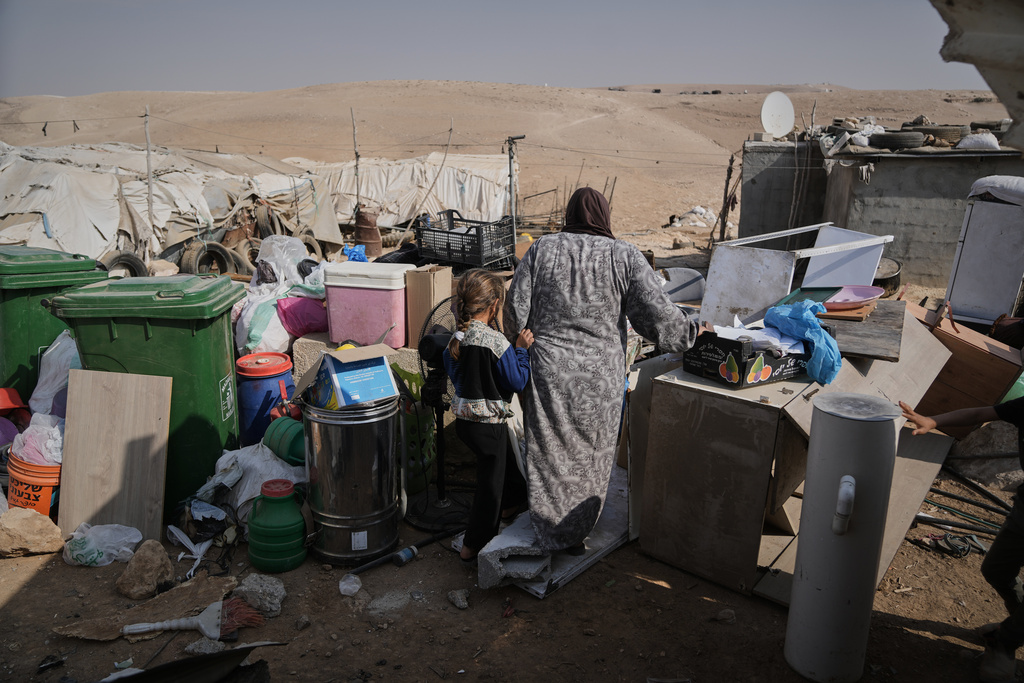 Members of the Hamamdeh family gather their belongings after Israeli authorities demolished their home in the West Bank village of Masafer Yatta Wednesday, Nov. 12, 2025. (AP Photo/Mahmoud Illean)