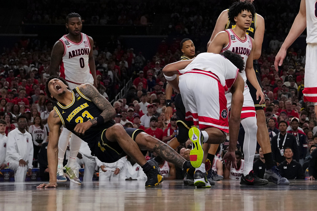 Michigan forward Yaxel Lendeborg (23) falls after play against Arizona during the first half of an NCAA college basketball tournament semifinal game at the Final Four, Saturday, April 4, 2026, in Indianapolis. (AP Photo/Abbie Parr)