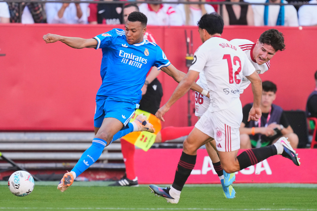 Real Madrid's Kylian Mbappe, left, controls the ball next to Sevilla's Gabriel Suazo and Sevilla's Joaquín Martínez Gauna during the Spanish La Liga soccer match at the Ramon Sanchez Pizjuan stadium in Seville, Spain, Sunday, May 17, 2026. (AP Photo/Jose Breton)