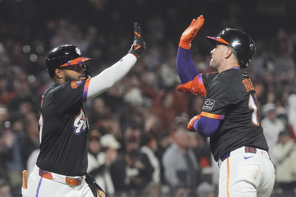 San Francisco Giants' Patrick Bailey, right, is congratulated by Heliot Ramos after hitting a home run against the Arizona Diamondbacks during the fifth inning of a baseball game in San Francisco, Tuesday, Sept. 9, 2025. (AP Photo/Jeff Chiu)