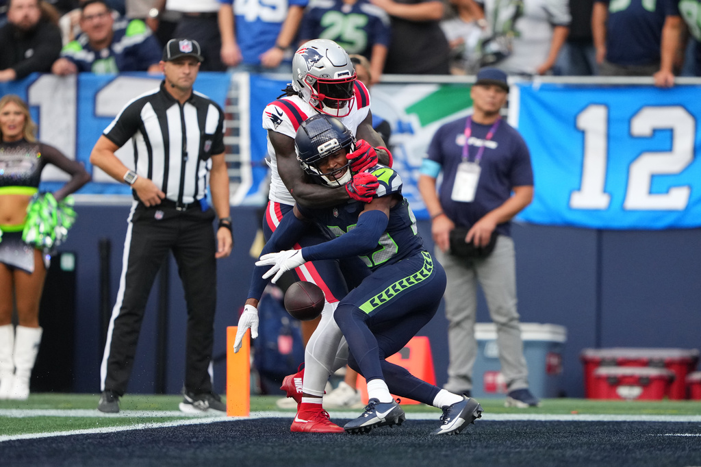 Seattle Seahawks cornerback Josh Jobe, front, causes pass interference against New England Patriots wide receiver A.J. Brown, behind, during the first half of an NFL football game, Wednesday, Sept. 9, 2026, in Seattle. (AP Photo/Lindsey Wasson)