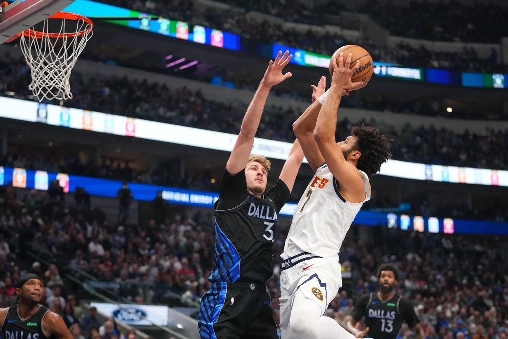 Denver Nuggets guard Jamal Murray, right, goes up for a basket against Dallas Mavericks forward Cooper Flagg during the first half of an NBA basketball game Wednesday, Jan. 14, 2026, in Dallas. (AP Photo/Julio Cortez)