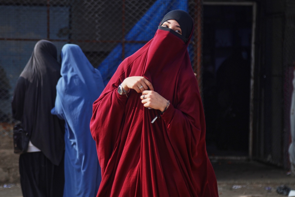 Women wait to enter a building supplying food and other goods at Roj camp, one of the detention facilities holding thousands of Islamic State group members and their families, in the al-Malikiyah area of northeastern Syria, Thursday, Jan. 29, 2026. (AP Photo/Baderkhan Ahmad)
