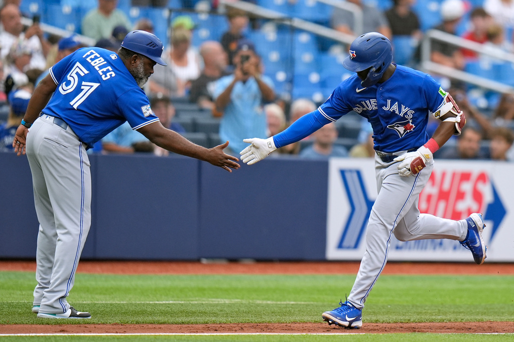 Toronto Blue Jays' Daz Cameron celebratees his home run off Tampa Bay Rays pitcher Ian Seymour with third base coach Carlos Febles (51) during the fifth inning of a baseball game Thursday, Aug. 20, 2026, in St. Petersburg, Fla. (AP Photo/Chris O'Meara)