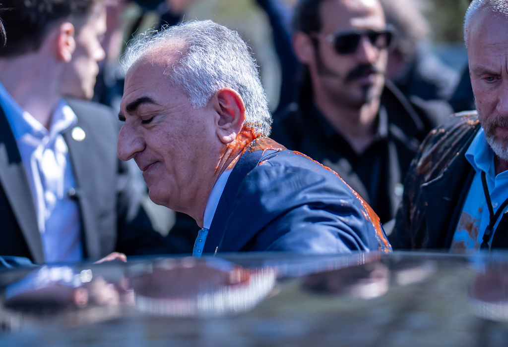 Iran's Reza Pahlavi, exiled son of Shah Reza Pahlavi, waves to supporters after he was attacked with a red fluid following a news conference in Berlin, Germany, Thursday, April 23, 2026. (Michael Kappeler/dpa via AP)
