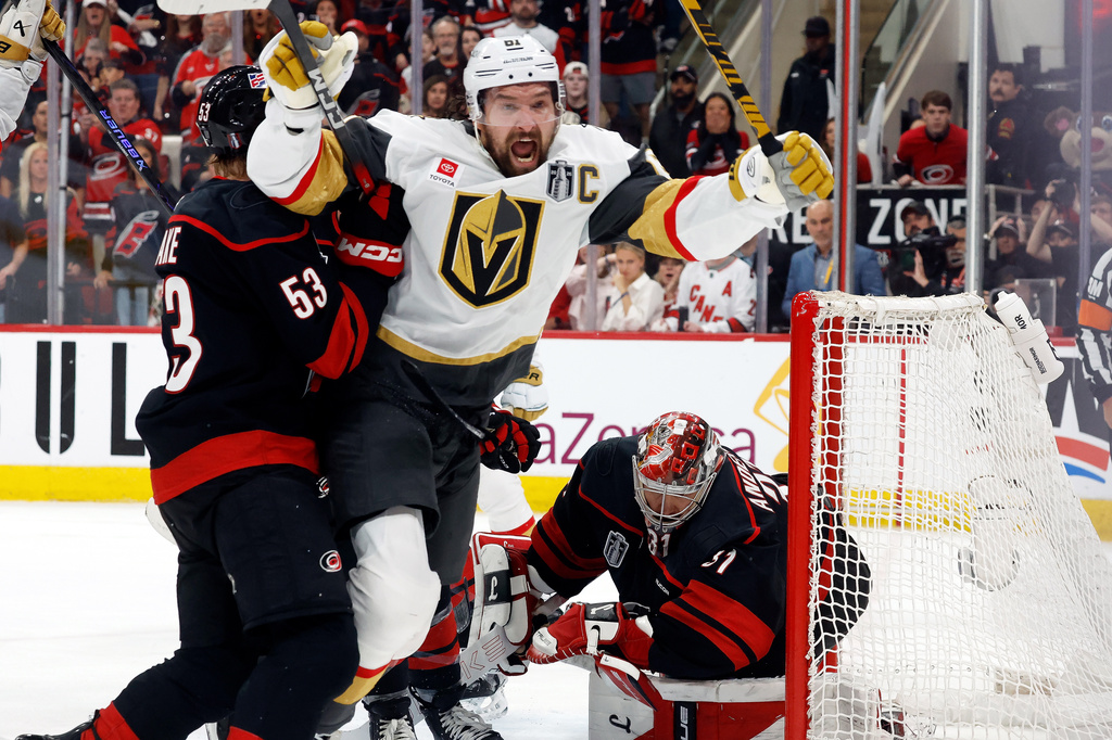 Vegas Golden Knights' Mark Stone (61) celebrates after his goal while in the grasp of Carolina Hurricanes' Jackson Blake (53) with Hurricanes goaltender Frederik Andersen, right, nearby during the third period in Game 2 of the NHL hockey Stanley Cup Final series in Raleigh, N.C., Thursday, June 4, 2026. (AP Photo/Karl DeBlaker)