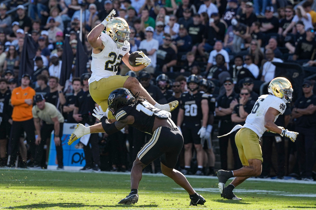 Notre Dame running back Aneyas Williams (22) leaps over Purdue defensive back John Slaughter (13) during the second half of an NCAA college football game in West Lafayette, Ind., Saturday, Sept. 26, 2026. (AP Photo/Michael Conroy)