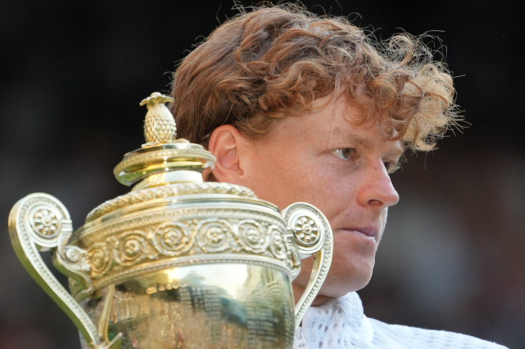 Jannik Sinner of Italy holds up the winners trophy after defeating Alexander Zverev of Germany in the men's singles final at Wimbledon Tennis Championships in London, Sunday, July 12, 2026. (AP Photo/Kin Cheung)