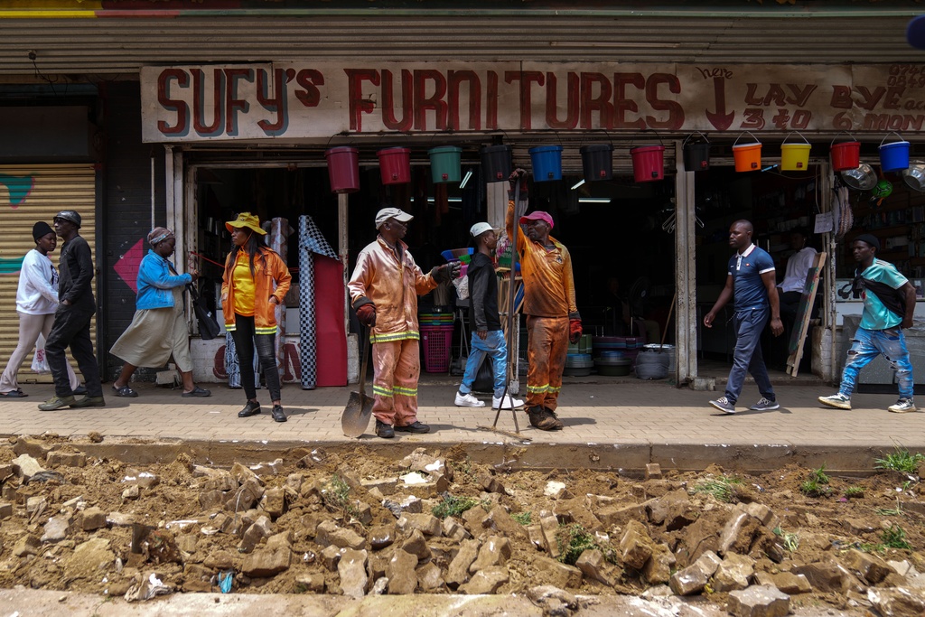Workers fix a road in Johannesburg's Soweto township as a massive cleanup job gets underway in anticipation of the upcoming G20 summit to be held in the South African economic capital, Friday, Nov. 14, 2025. (AP Photo/Jerome Delay)