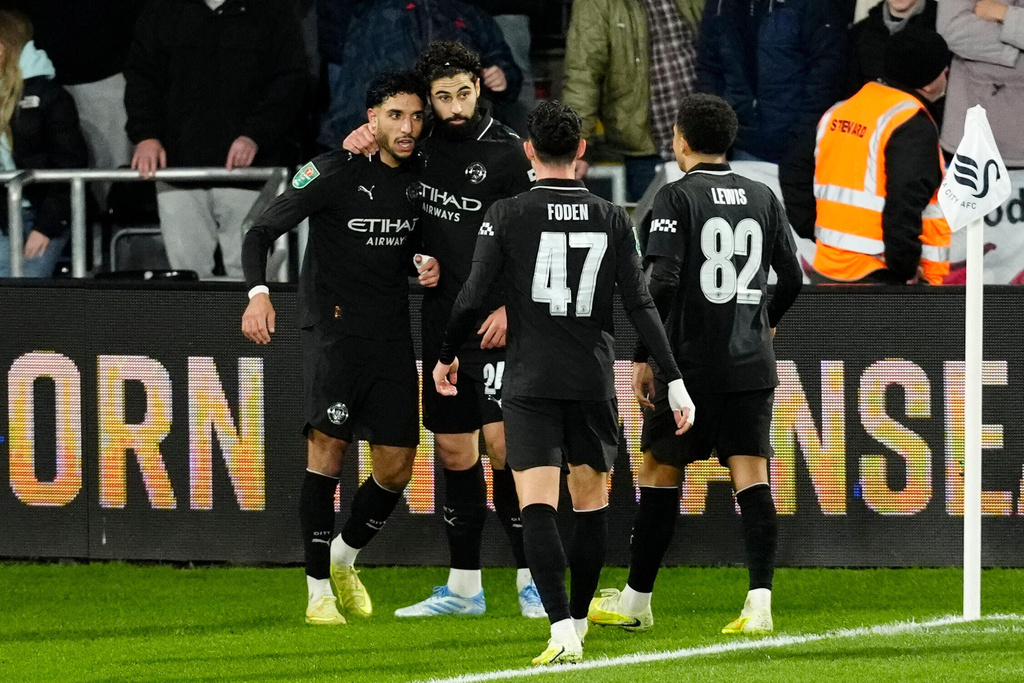 Manchester City's Omar Marmoush, left, celebrates scoring with teammates during the English League Cup fourth round soccer match between Swansea City and Manchester City in Swansea, Wales, Wednesday Oct. 29, 2025. (Nick Potts/PA via AP)