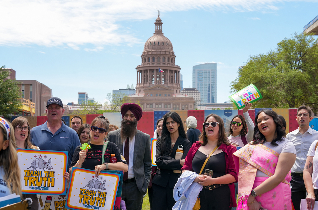 People hold signs reading "Teach the Truth" during a rally on the Capitol Mall outside the Barbara Jordan State Office Building, where the State Board of Education meets, in Austin, Texas, Tuesday, April 7, 2026. (Jay Janner/Austin American-Statesman via AP)