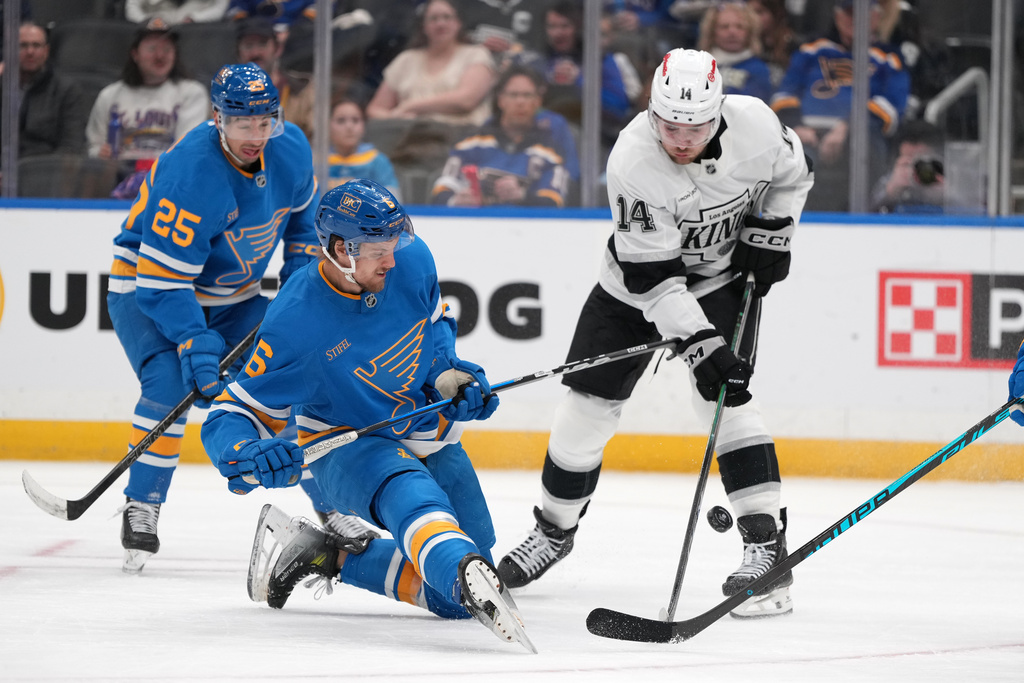 St. Louis Blues' Philip Broberg (6) and Los Angeles Kings' Alex Laferriere (14) battle for a loose puck during the third period of an NHL hockey game Saturday, Jan. 24, 2026, in St. Louis. (AP Photo/Jeff Roberson)