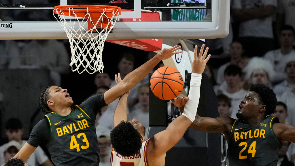 Baylor guard Cameron Carr (43) and guard Tounde Yessoufou (24) try to block a shot by Iowa State forward Joshua Jefferson, center, during the first half of an NCAA college basketball game, Saturday, Feb. 7, 2026, in Ames, Iowa. (AP Photo/Charlie Neibergall)