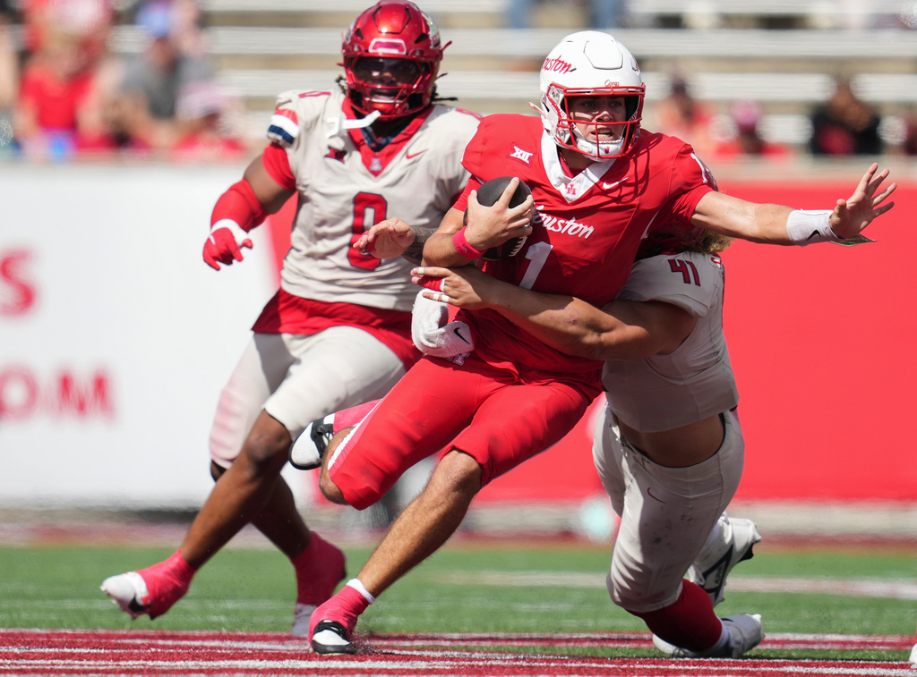 Houston quarterback Conner Weigman (1) is tackled from behind by Arizona defensive lineman Julian Savaiinaea (41) after picking up a first down during the first half of an NCAA college football game, Saturday, Oct. 18, 2025, in Houston. (Jason Fochtman/Houston Chronicle via AP)