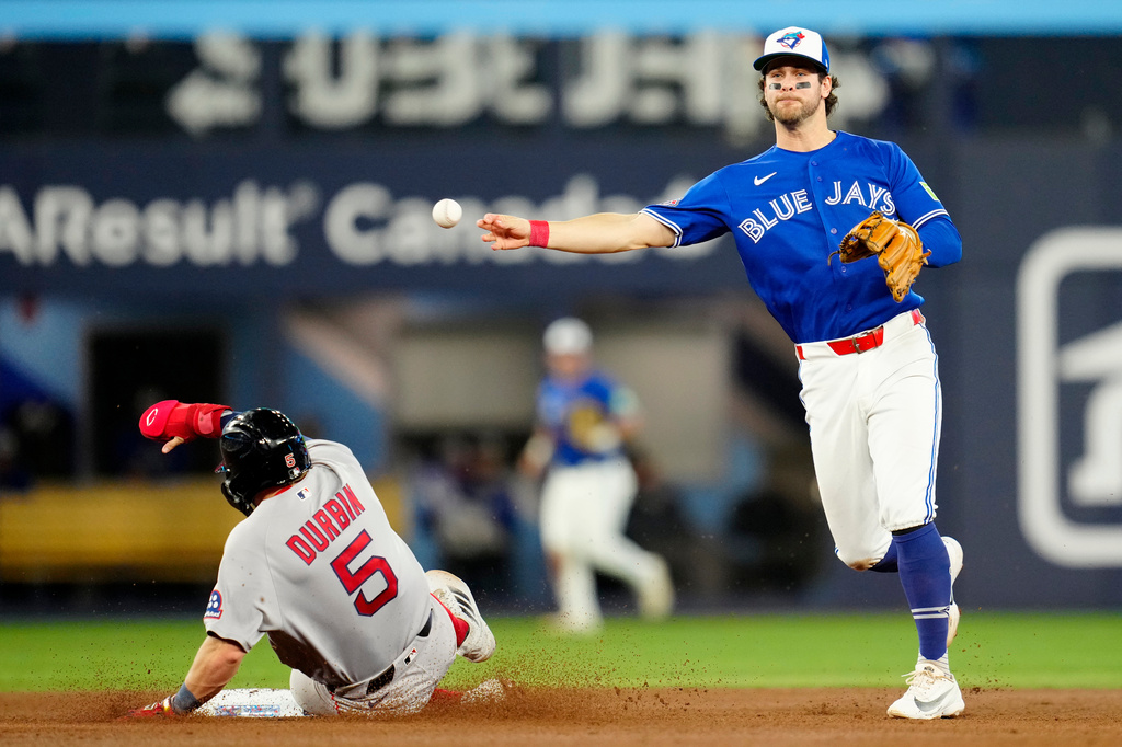 Toronto Blue Jays third baseman Ernie Clement, right, forces out Boston Red Sox's Caleb Durbin (5) and throws back to first base but fails to make a double play during fifth-inning baseball game action in Toronto, Monday, April 27, 2026. (Frank Gunn/The Canadian Press via AP)