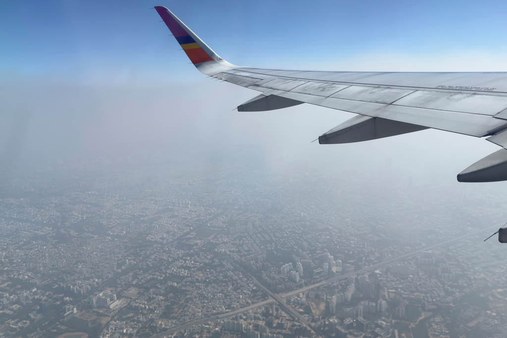 A layer of smog hangs over the skyline as seen from an aircraft window in New Delhi, India, Sunday, Oct. 26, 2025. (AP Photo/Yirmiyan Arthur)
