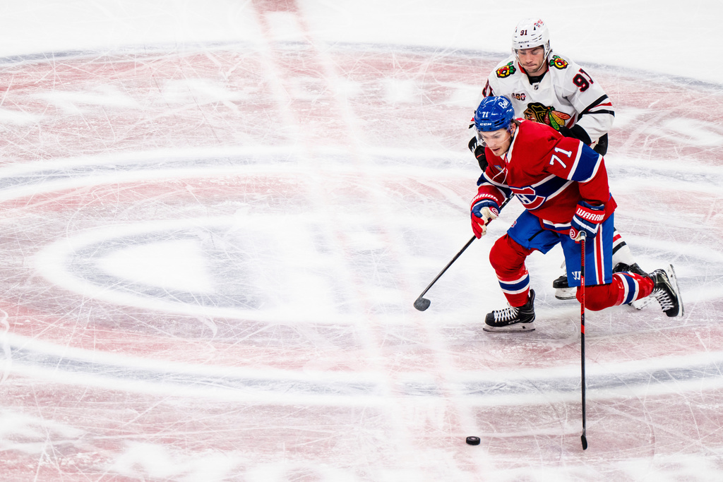 Montreal Canadiens' Jake Evans (71) and Chicago Blackhawks' Frank Nazar (91) vie for the puck during first-period NHL hockey game action in Montreal, Thursday, Dec. 18, 2025. (Christopher Katsarov/The Canadian Press via AP)