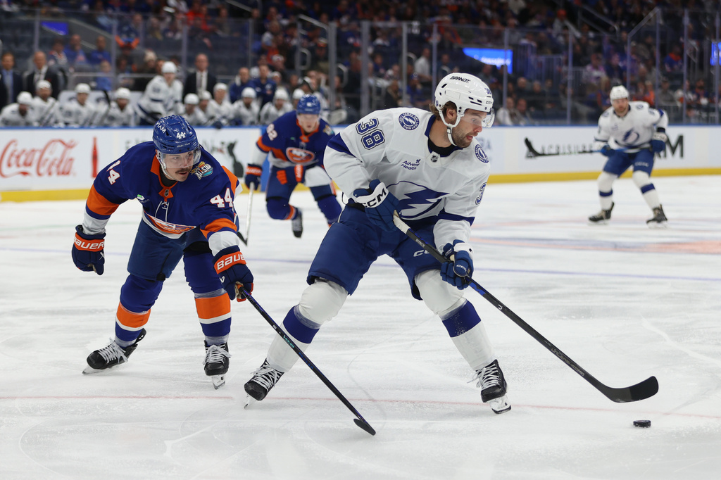 Tampa Bay Lightning's Brandon Hagel (38) skates with the puck against New York Islanders' Jean-Gabriel Pageau (44) during the first period of an NHL hockey game, Saturday, Oct. 10, 2026, in Elmont, N.Y. (AP Photo/Pamela Smith)