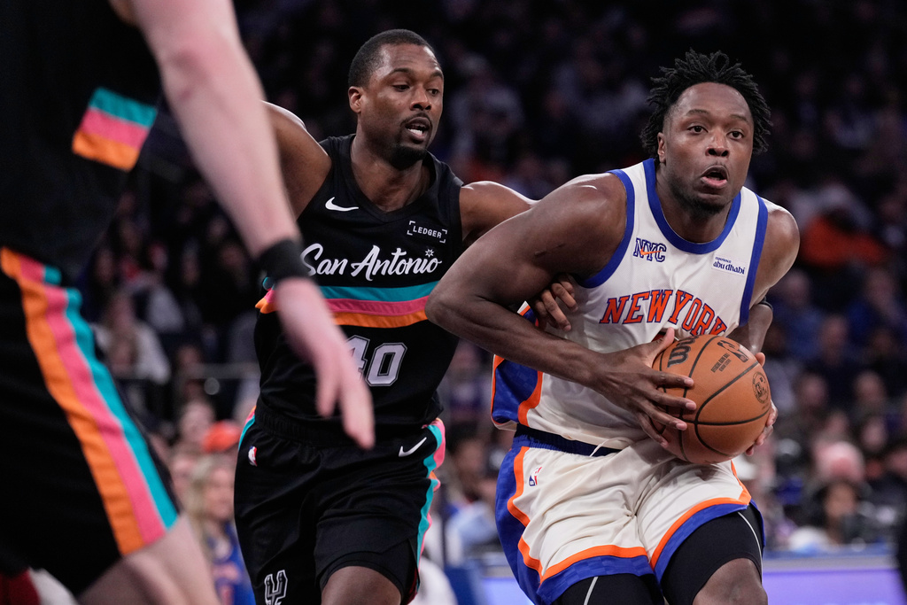 New York Knicks' Og Anunoby, right, drives to the basket past San Antonio Spurs' Harrison Barnes during the first half of an NBA basketball game Sunday, March 1, 2026, in New York. (AP Photo/Seth Wenig)