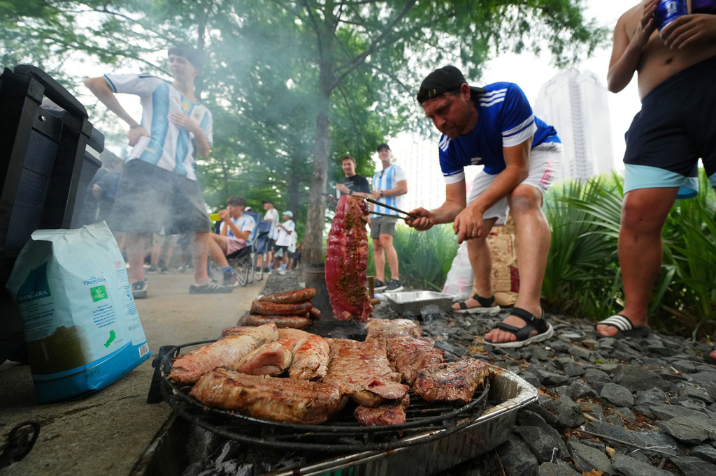 Argentina supporters grill during a rally ahead of their team's World Cup Group J soccer match against Austria, Sunday, June 21, 2026, in Dallas. (AP Photo/Julio Cortez)