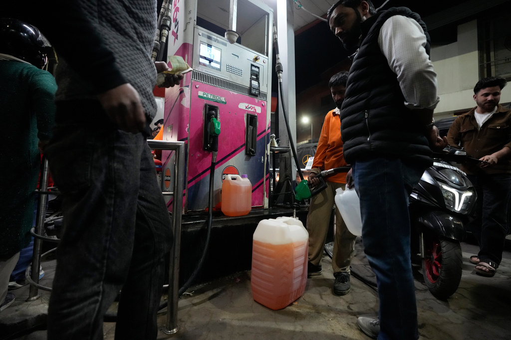 FILE - People store fuel in a plastic can at a petrol pump amid fears of a possible shortage due to the US Iran war, in Srinagar, Indian controlled Kashmir, Wednesday, March 25, 2026. (AP Photo/Mukhtar Khan, file)