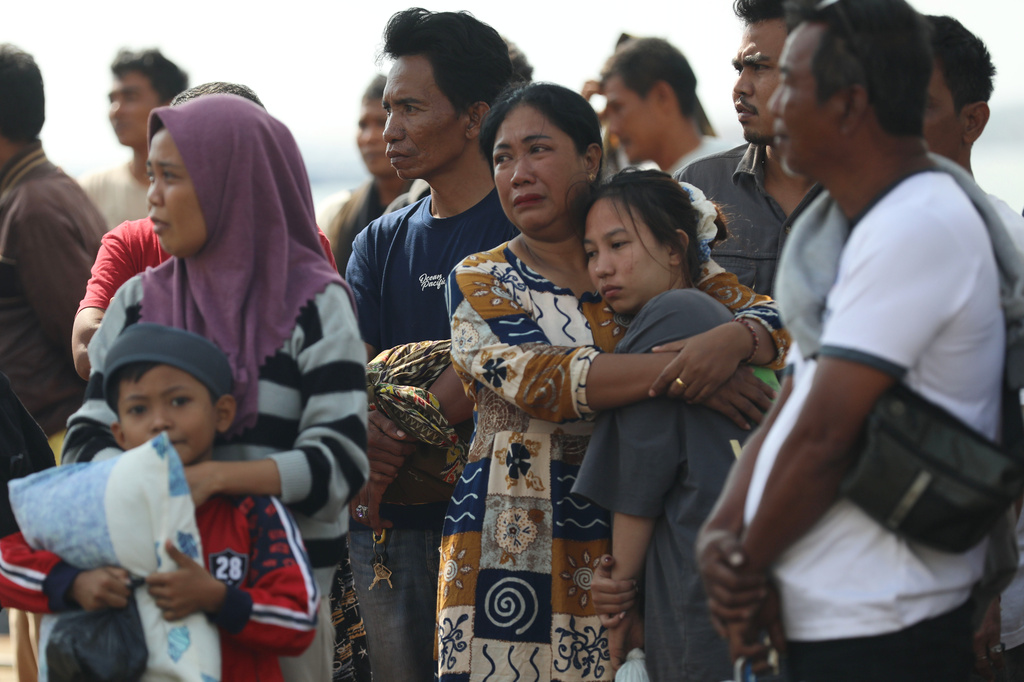 Survivors of a ferry fire comfort each other before disembarking from a rescue ship upon arrival at Tanjung Perak Port in Surabaya, East Java, Indonesia, Tuesday, Aug. 4, 2026. (AP Photo/Trisnadi)