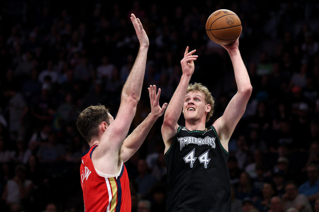 Minnesota Timberwolves center Rocco Zikarsky, right, shoots over New Orleans Pelicans center Hunter Dickinson (4) during the first half of an NBA basketball game Sunday, April 12, 2026, in Minneapolis. (AP Photo/Matt Krohn)
