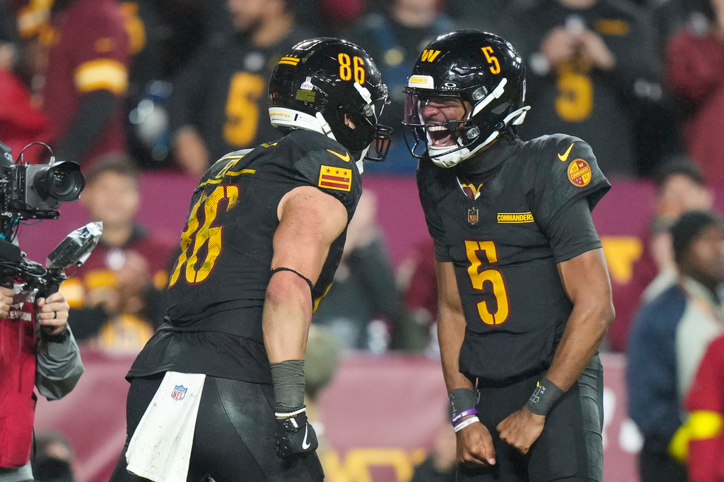 Washington Commanders tight end Zach Ertz (86) and quarterback Jayden Daniels (5) celebrate connecting for a touchdown during the second half of an NFL football game Monday, Oct. 13, 2025, in Landover, Md. (AP Photo/Stephanie Scarbrough)