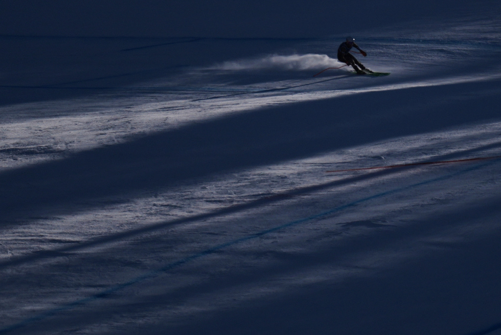 Finland's Elian Lehto is silhouetted as he speeds down the course of an alpine ski men's downhill portion of a team combined race, at the 2026 Winter Olympics, in Bormio, Italy, Monday, Feb. 9, 2026. (AP Photo/Rebecca Blackwell)