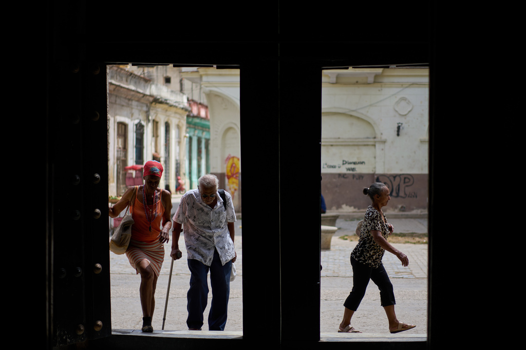 Elderly residents arrive at the Church of the Holy Spirit to receive free meals provided through a church-run program held three times a week, in Old Havana, Cuba, Friday, April 10, 2026. (AP Photo/Ramon Espinosa)