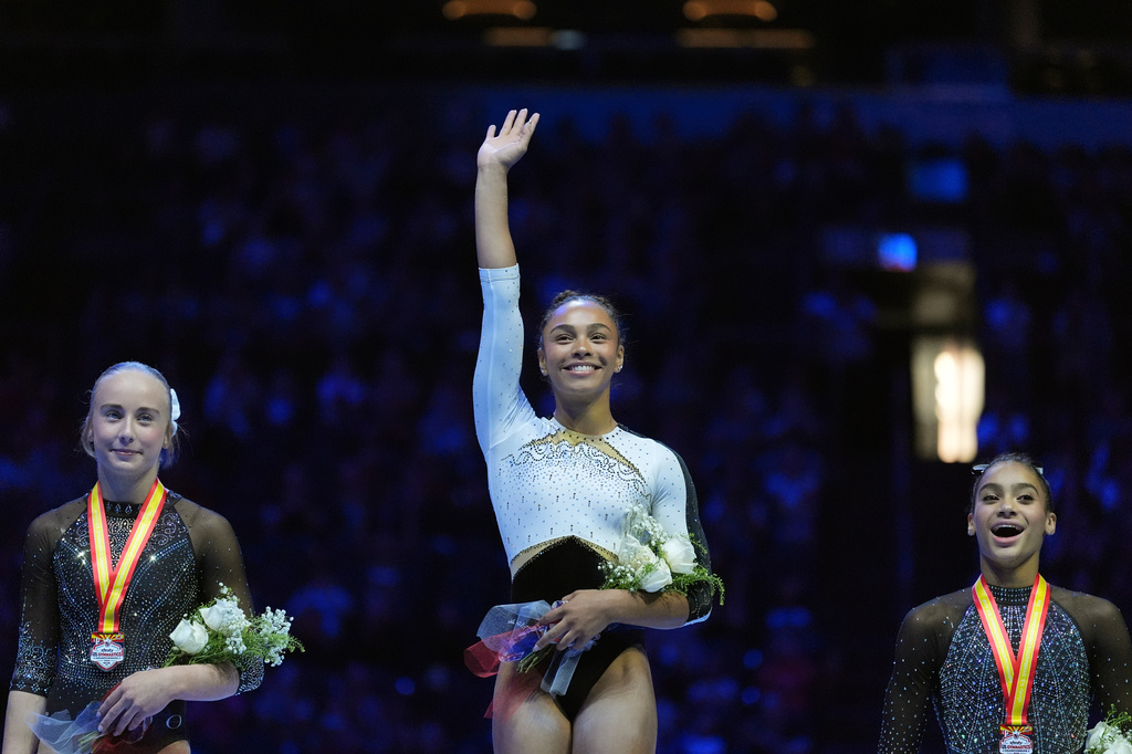 All Around second place finisher Claire Pease, left, All Around Champion Hezly Rivera, center, and All Around third place finisher Charleigh Bullock, right, stand on the podium at the U.S. Gymnastics Championships, Sunday, Aug. 9, 2026, in Phoenix. (AP Photo/Ross D. Franklin)