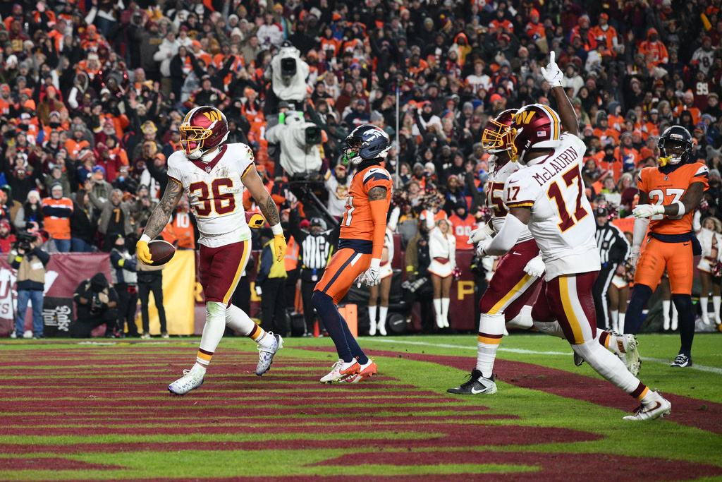 Washington Commanders running back Chris Rodriguez Jr. (36) scores past Denver Broncos cornerback Kris Abrams-Draine as Commanders' Terry McLaurin (17) watches during the first half of an NFL football game Sunday, Nov. 30, 2025, in Landover, Md. (AP Photo/Nick Wass)