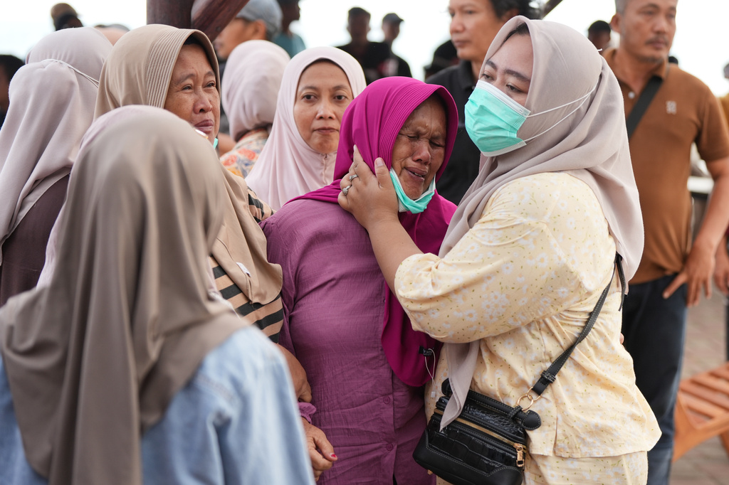 Jannah, center, the wife of the boat captain carrying journalists who went missing while covering the eruption of Mount Anak Krakatau, is comforted by relatives in Pandeglang, Indonesia, Wednesday, Sept. 9, 2026. (AP Photo/Dziki Oktomauliyadi)