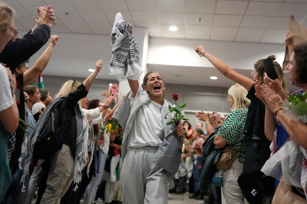 Activists arrive at the Eleftherios Venizelos International Airport in Athens, Monday, Oct. 6, 2025 after being deported from Israel for taking part in a Gaza-bound aid flottila. (AP Photo/Petros Giannakouris)