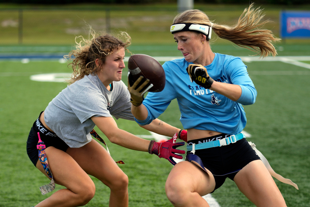 FILE - Ashlea Klam, right, tries to evade a defender during a training session for her flag football team at Keiser University in West Palm Beach, Fla., Nov. 30, 2023. (AP Photo/Rebecca Blackwell, File)