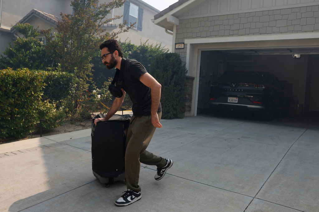 A resident evacuates during as the Sandy Fire approaches, Tuesday, May 19, 2026, in Simi Valley, Calif. (AP Photo/Caroline Brehman)