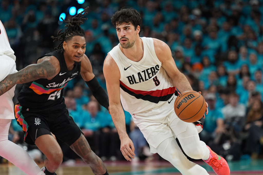 Portland Trail Blazers forward Deni Avdija (8) drives against San Antonio Spurs guard Devin Vassell (24) during the first half in Game 1 of a first-round NBA playoffs basketball series in San Antonio, Sunday, April 19, 2026. (AP Photo/Eric Gay)