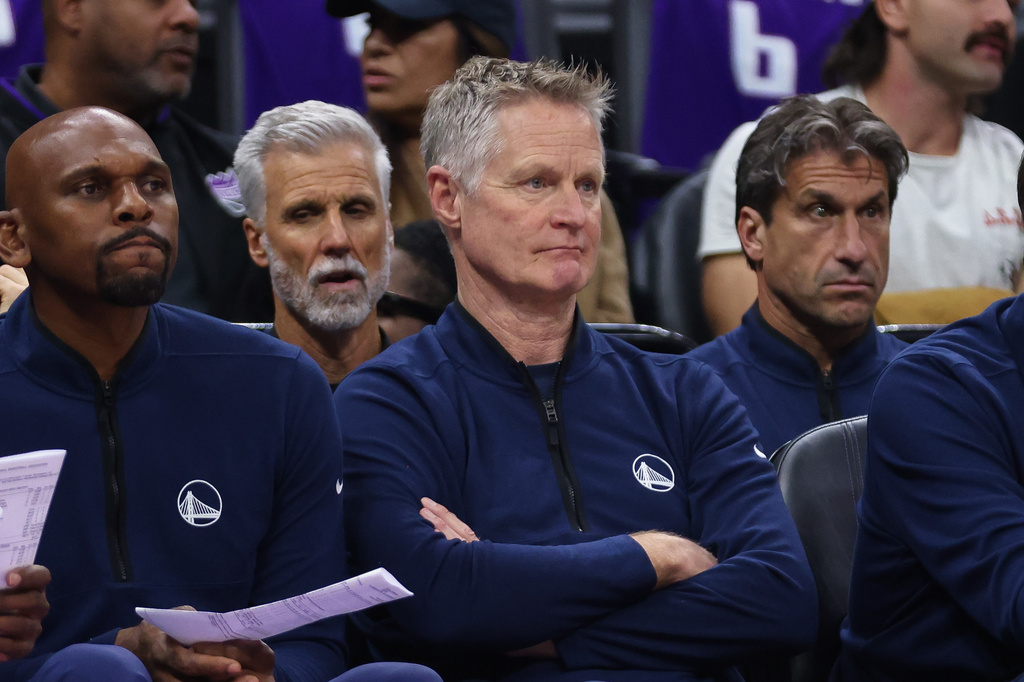 Golden State Warriors head coach Steve Kerr, right, looks on from the bench during the first half of an NBA basketball game against the Sacramento Kings, Friday, April 10, 2026, in Sacramento, Calif. (AP Photo/Scott Marshall)