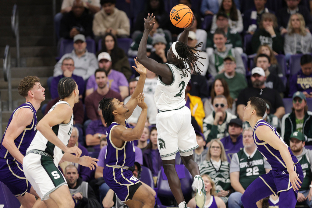 Michigan State guard Kur Teng (2) shoots the ball as Washington guard Quimari Peterson, center, defends during the first half of an NCAA college basketball game, Saturday, Jan. 17, 2026, in Seattle. (AP Photo/Jason Redmond)