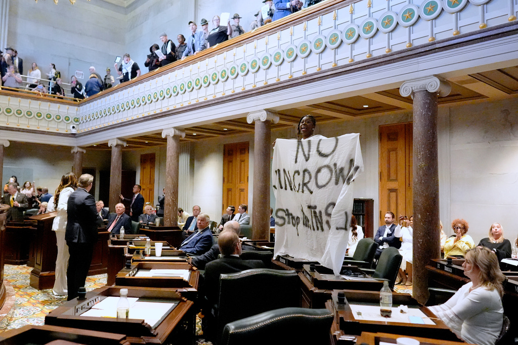 Sen. Charlane Oliver, D-Nashville, holds a banner and protests atop her desk on the Senate floor during a special session of the state legislature to redraw U.S. Congressional voting maps Thursday, May 7, 2026, in Nashville, Tenn. (AP Photo/George Walker IV)