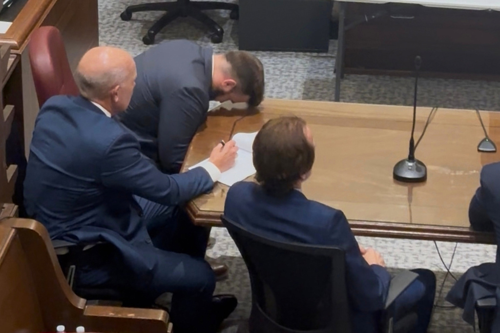 Former Capitol Police officer Steven Frederick Jr., top, reacts on Monday, Sept. 28, 2026, at the Hinds County Courthouse in Jackson, Miss., after a jury acquitted him of manslaughter for shooting at a Black man, Jaylen Lewis, in a 2022 traffic stop. Beside him are defense attorneys Boty McDonald, center, and Merrida Coxwell Jr. (Madeline Nguyen/Mississippi Today via AP)